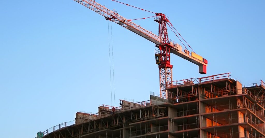 Tower crane on a high-rise building under construction at sunset, showcasing modern urban development.